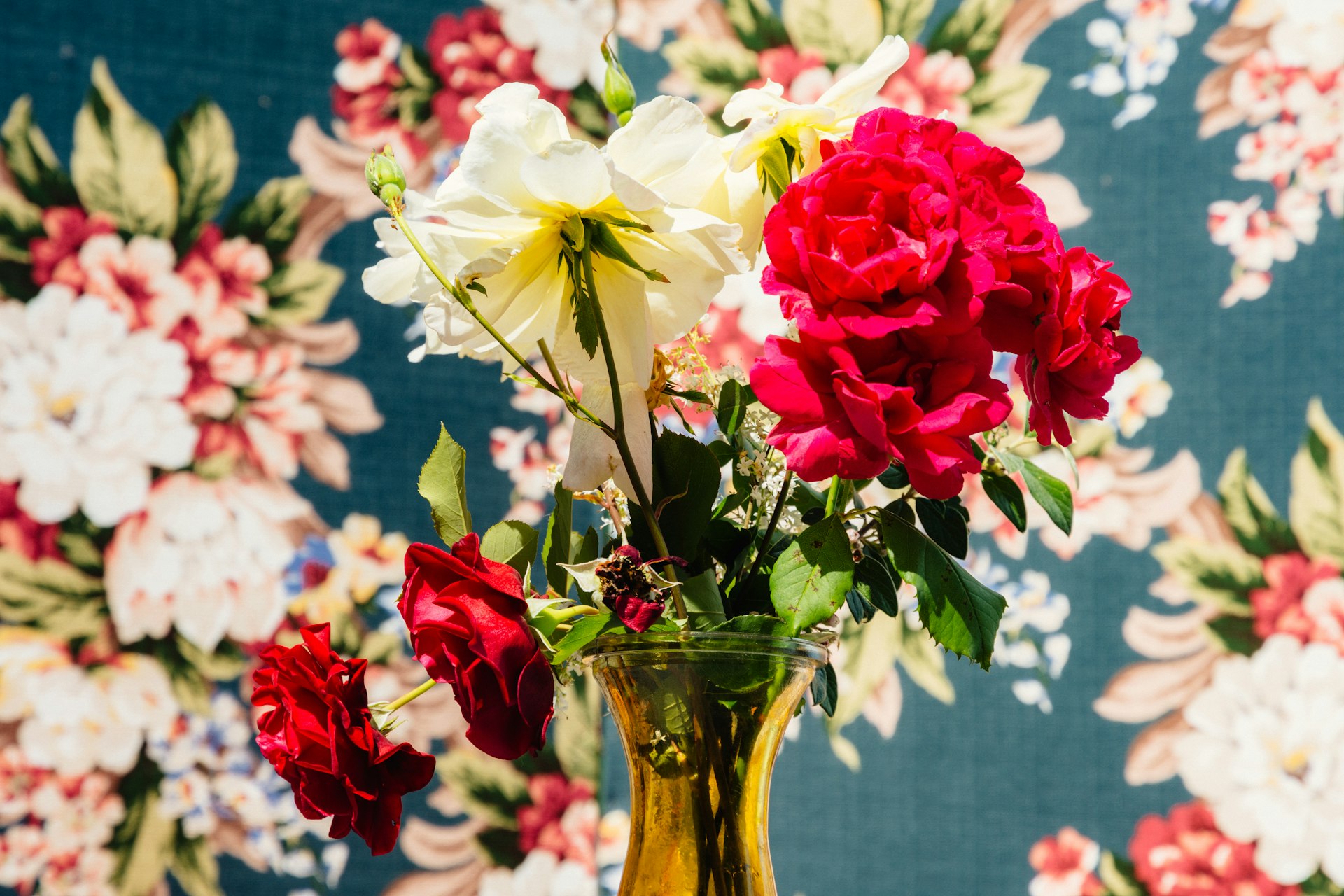 red and white roses in clear glass vase